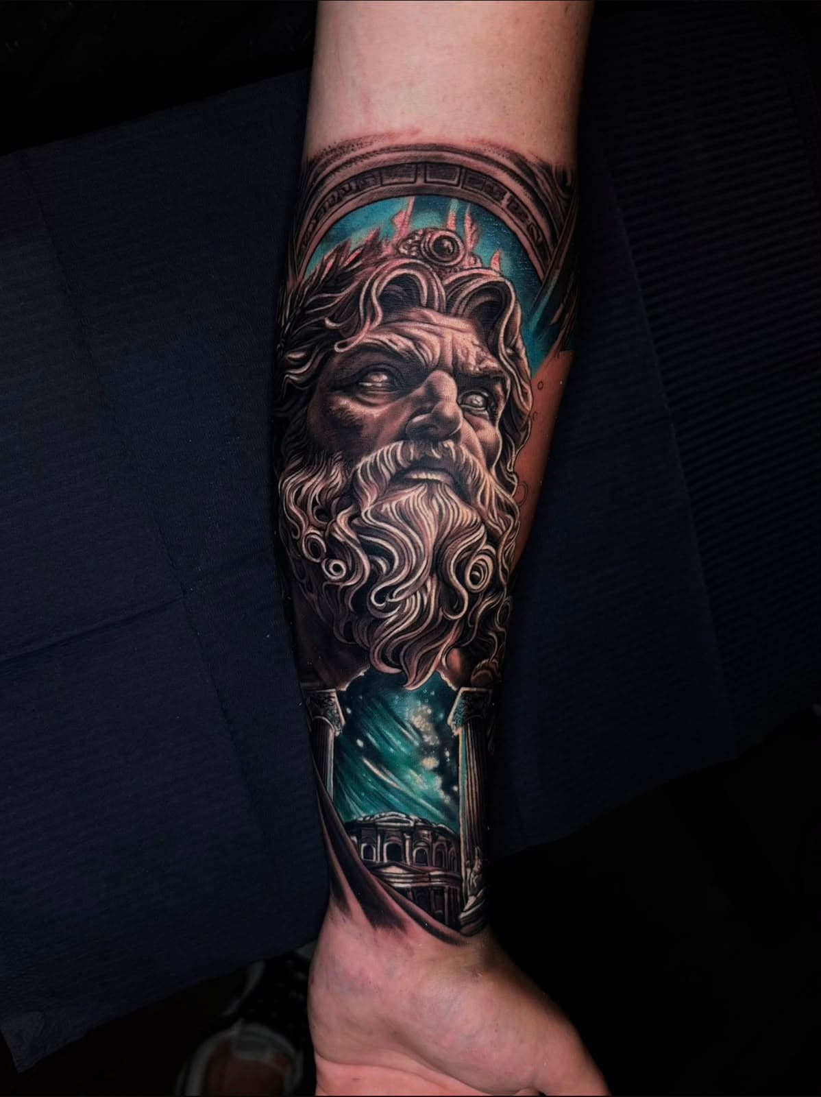 Poseidon mit türkisfarbenem Hintergrund auf dem Unterarm